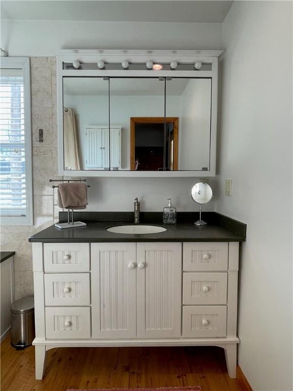 bathroom with vanity, hardwood / wood-style flooring, and a wealth of natural light