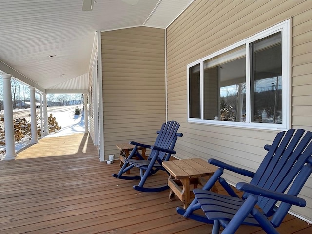 snow covered deck featuring covered porch