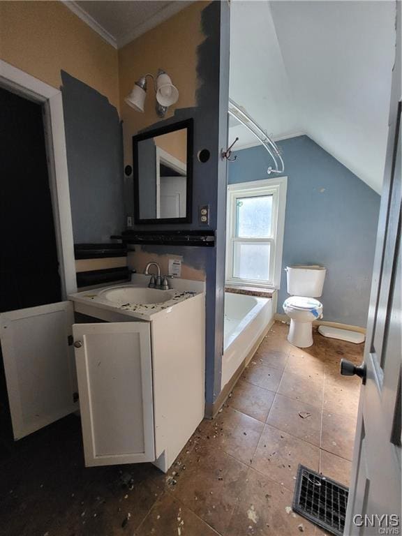 bathroom with lofted ceiling, vanity, ornamental molding, a tub to relax in, and toilet