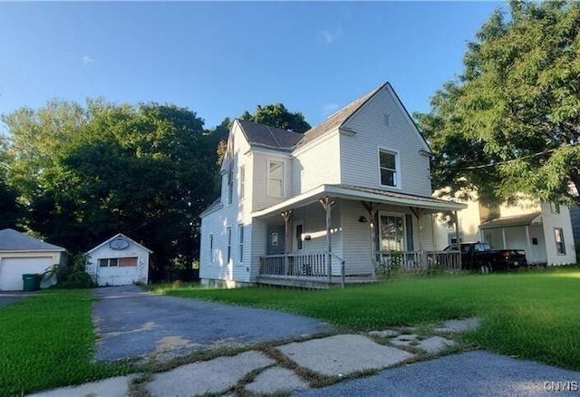 view of front of property with a porch, a garage, an outdoor structure, and a front lawn