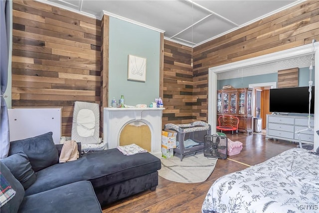 bedroom featuring crown molding, wooden walls, and wood-type flooring