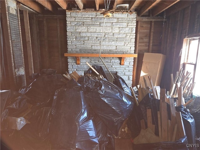 misc room featuring wooden walls and a fireplace