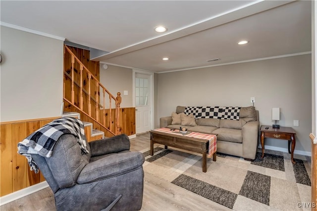 living room with ornamental molding, wood-type flooring, and wooden walls