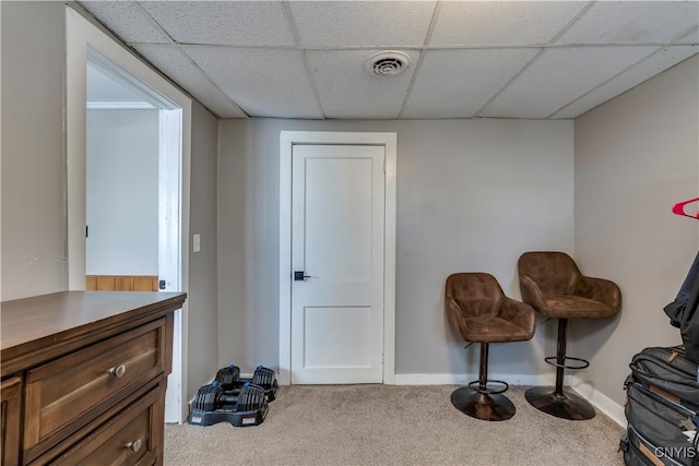 living area with carpet flooring and a drop ceiling