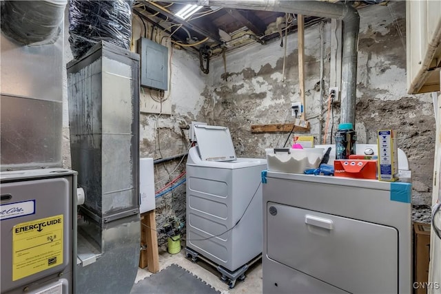 utility room with independent washer and dryer, electric panel, and heating unit