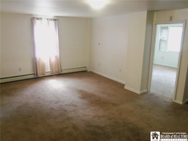 carpeted spare room featuring a baseboard heating unit