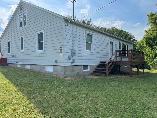 back of house with a deck and a lawn