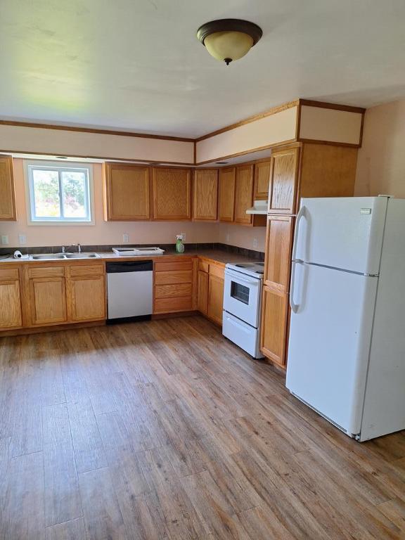 kitchen featuring white appliances, sink, and light wood-type flooring