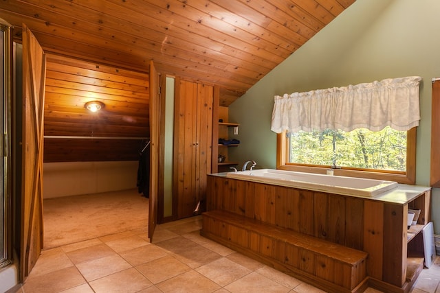 bathroom featuring tile patterned floors, a tub to relax in, vaulted ceiling, and wooden ceiling