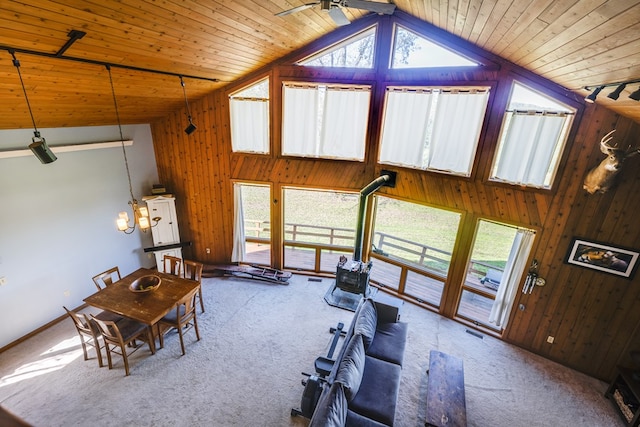 workout area with carpet flooring, high vaulted ceiling, and wood walls