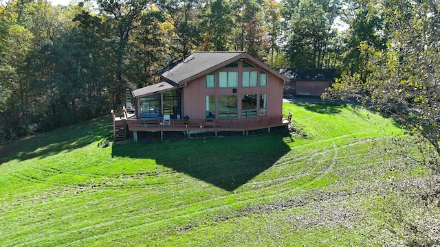 rear view of house featuring a wooden deck and a yard