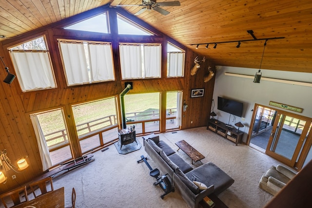 living room featuring high vaulted ceiling, wooden walls, rail lighting, carpet, and wooden ceiling