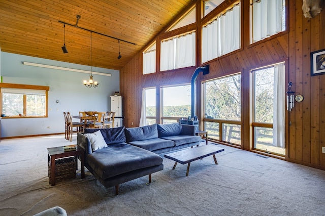 living room featuring wooden walls, high vaulted ceiling, carpet, wooden ceiling, and a chandelier