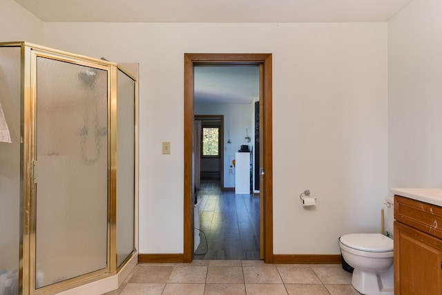 bathroom featuring walk in shower, vanity, toilet, and tile patterned flooring