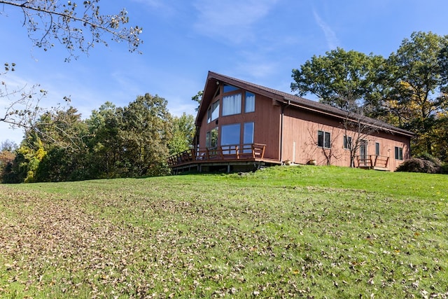 view of side of home with a wooden deck and a lawn