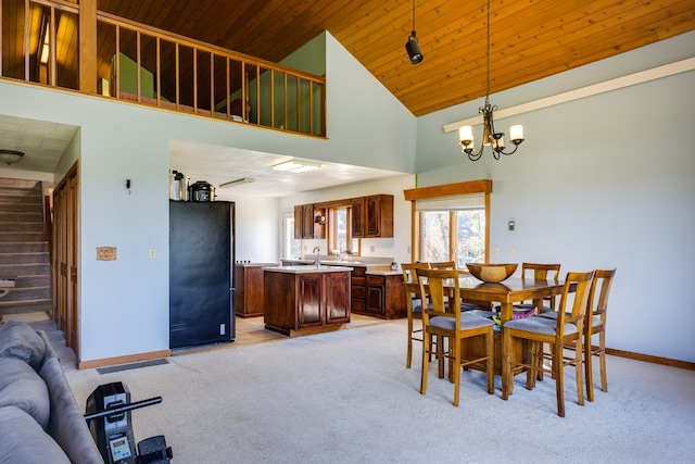 dining space featuring light carpet, a notable chandelier, wooden ceiling, and high vaulted ceiling