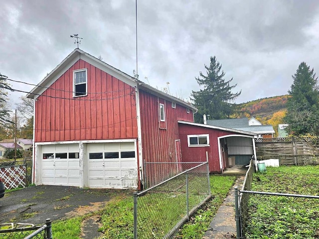 view of side of home featuring a garage and an outdoor structure