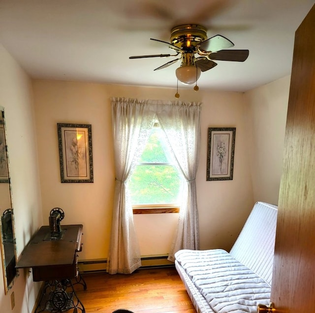 sitting room featuring a baseboard radiator, ceiling fan, and light hardwood / wood-style flooring