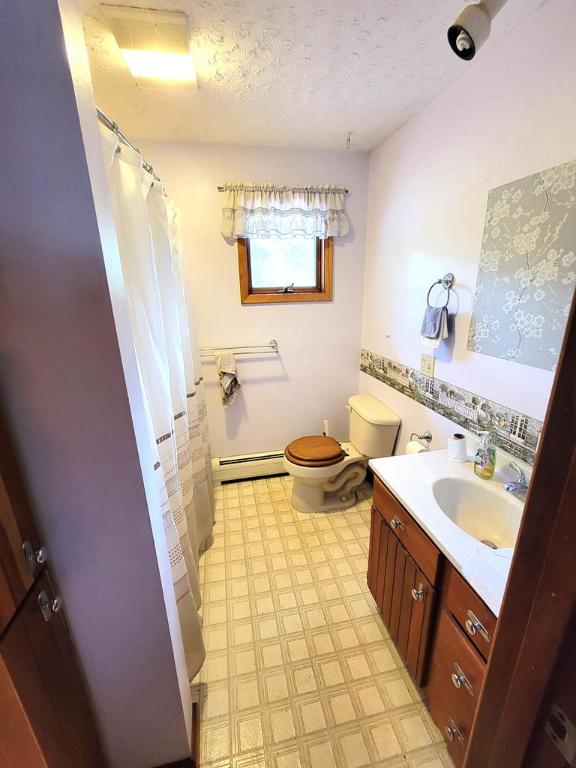 bathroom with a baseboard radiator, vanity, toilet, and a textured ceiling