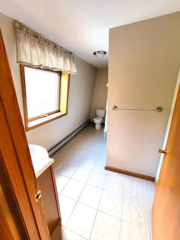 bathroom with a baseboard radiator, vanity, toilet, and tile patterned flooring