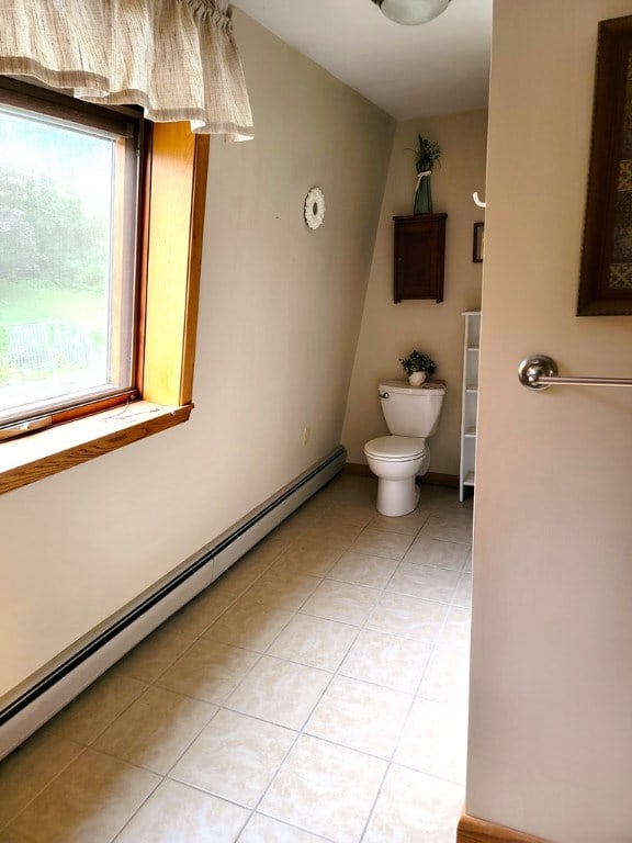 bathroom featuring tile patterned floors, baseboard heating, and toilet