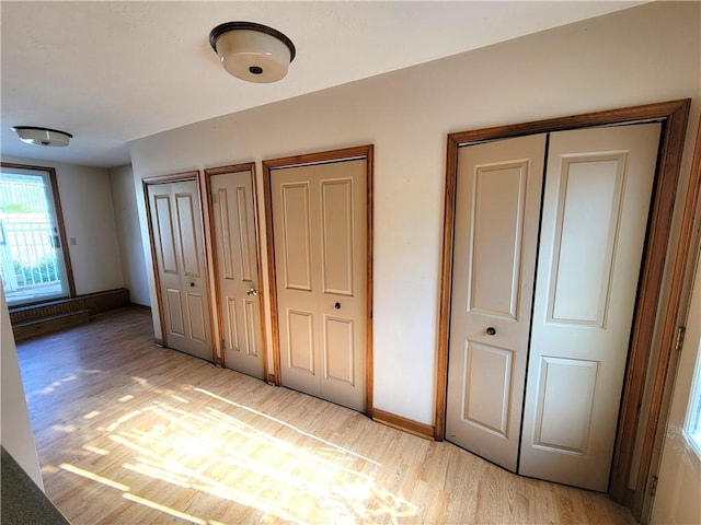 3530 Coats Rd, Hector, NY 14818 - unfurnished bedroom featuring multiple closets, light wood finished floors, and baseboards