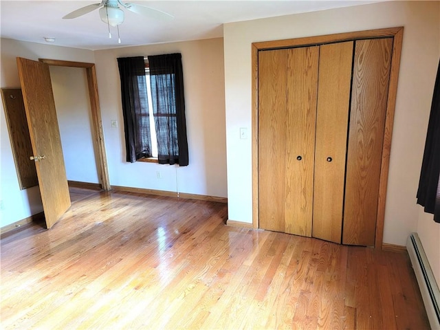 3530 Coats Rd, Hector, NY 14818 - unfurnished bedroom featuring a baseboard heating unit, light wood-style floors, a closet, and baseboards