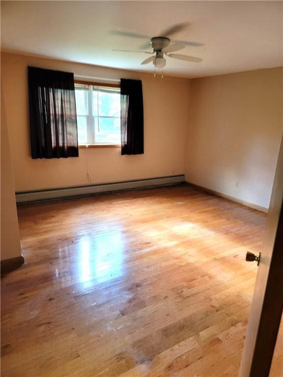 3530 Coats Rd, Hector, NY 14818 - spare room featuring a baseboard radiator, ceiling fan, light wood-style floors, and baseboards