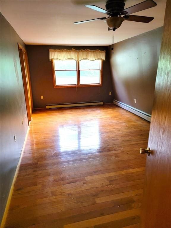 3530 Coats Rd, Hector, NY 14818 - empty room featuring a baseboard heating unit, wood finished floors, and baseboards