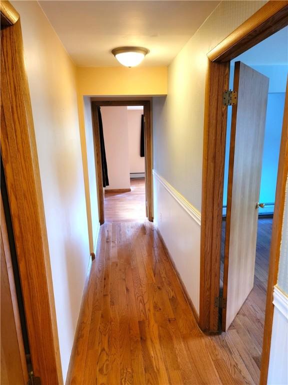 3530 Coats Rd, Hector, NY 14818 - hallway featuring wood finished floors, baseboard heating, and baseboards