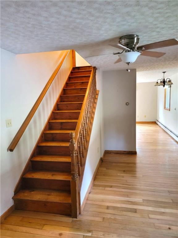3530 Coats Rd, Hector, NY 14818 - staircase with a ceiling fan, a textured ceiling, baseboards, and hardwood / wood-style flooring