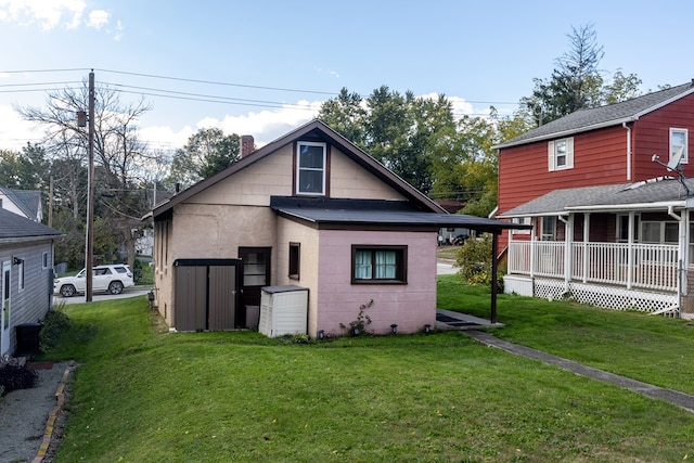 back of house with a yard and covered porch