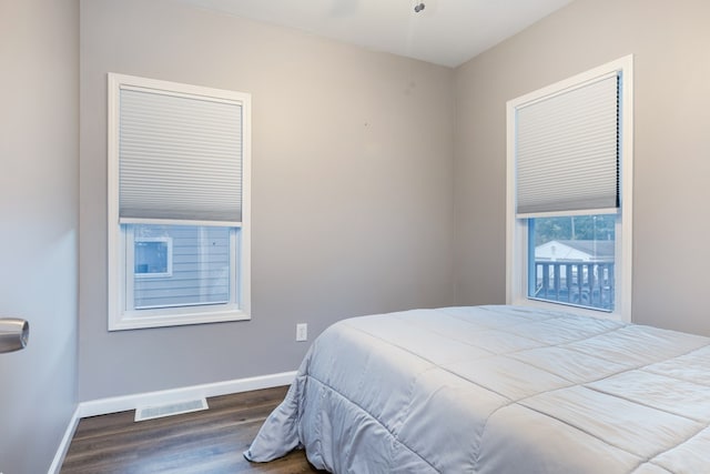 bedroom with dark hardwood / wood-style flooring