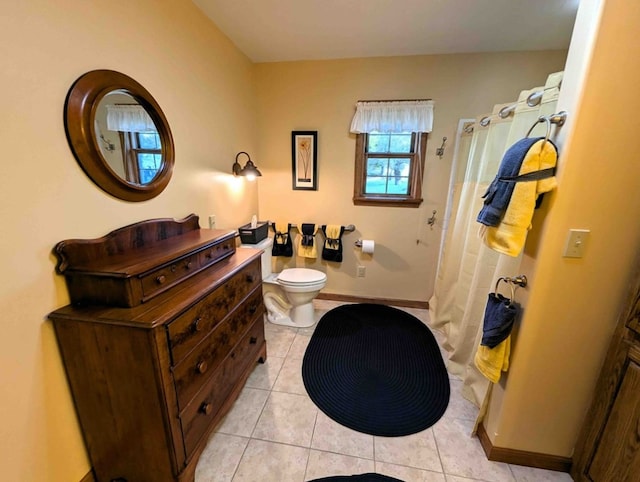 bathroom featuring a shower with shower curtain, toilet, and tile patterned flooring