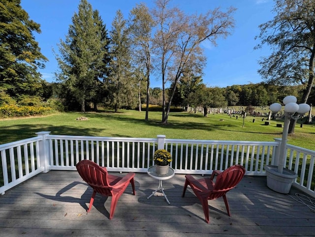 wooden terrace featuring a yard