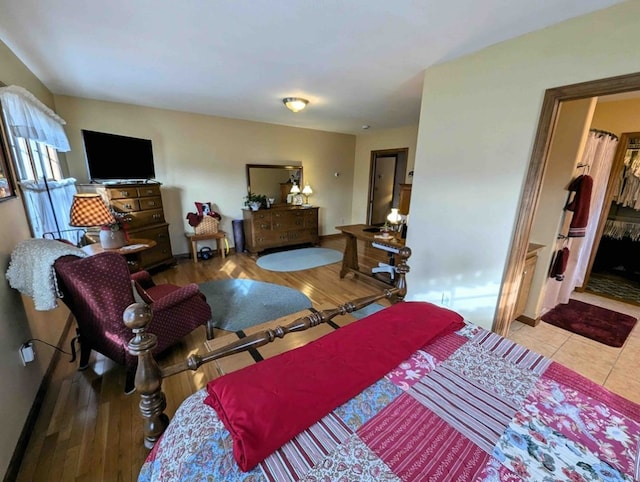 bedroom with hardwood / wood-style flooring and a spacious closet