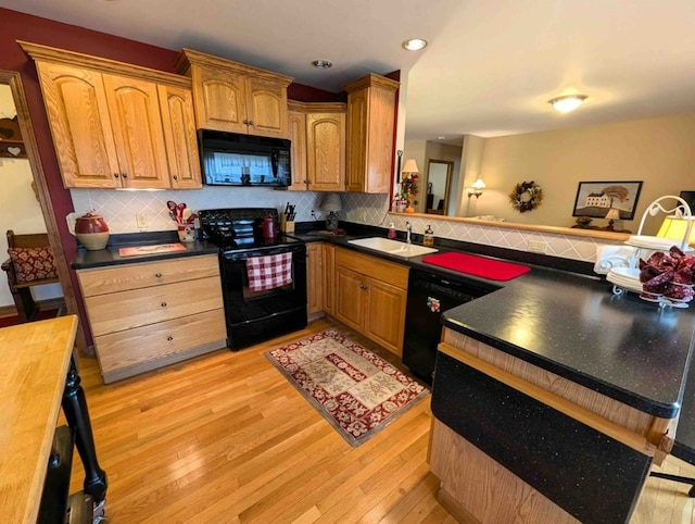 kitchen with light wood-type flooring, sink, decorative backsplash, and black appliances