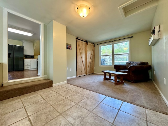 living room featuring light tile patterned flooring and a barn door