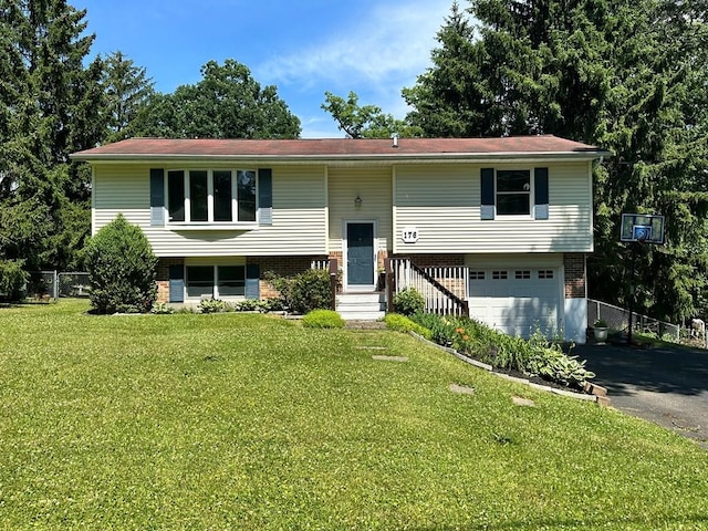 raised ranch featuring a garage and a front yard