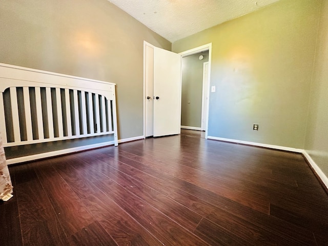 unfurnished bedroom featuring dark hardwood / wood-style floors and a textured ceiling