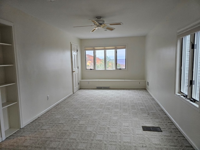 carpeted spare room with built in features and ceiling fan