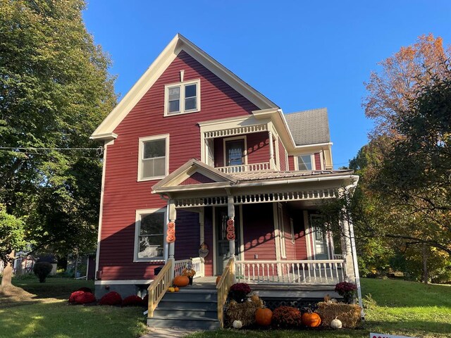 view of front of home with covered porch and a front lawn