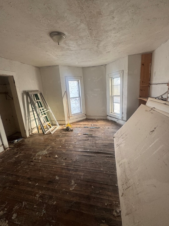 misc room featuring dark wood-type flooring and a textured ceiling