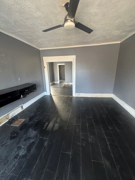 unfurnished living room with dark hardwood / wood-style flooring, a textured ceiling, crown molding, and ceiling fan