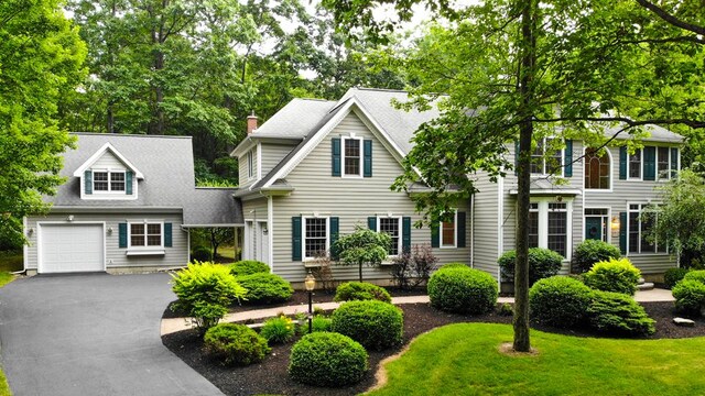 colonial home featuring a garage and a front lawn