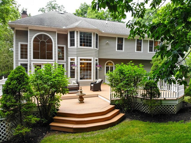 rear view of property featuring a wooden deck