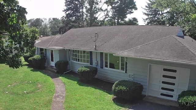 single story home with a garage and a front yard