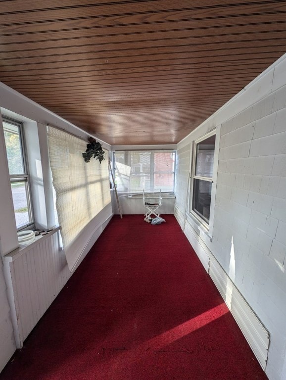 unfurnished sunroom featuring wood ceiling and radiator