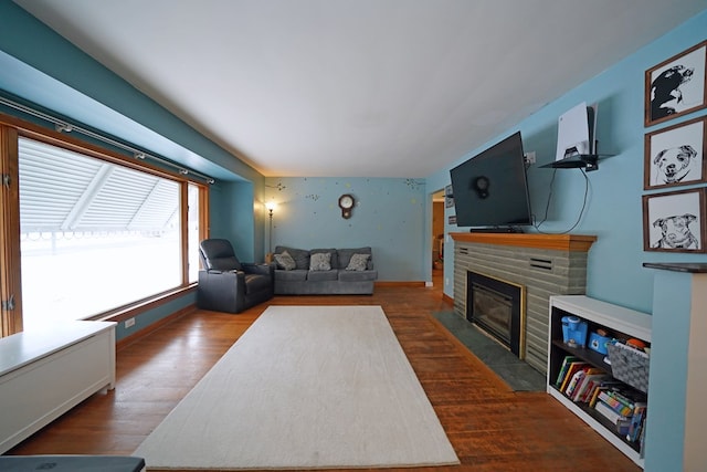 living room with dark wood-type flooring and a brick fireplace