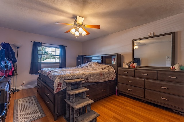 bedroom featuring ceiling fan, a textured ceiling, and light wood-type flooring